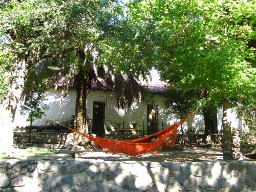una hamaca frente a una casa bajo los árboles en La Casona del Río en Valle Hermoso