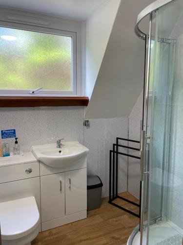 a bathroom with a sink and a shower at West Haven Lodge in Aultbea