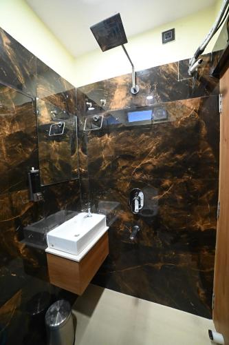 a bathroom with a sink and a mirror at Eloras Inn in Siliguri