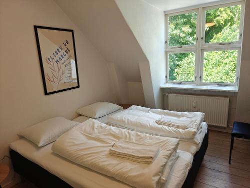 two beds in a room with two windows at Satellit lejligheder Vejle C in Vejle
