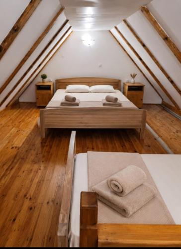 a attic bedroom with two beds and wooden floors at Katun Mokra in Podgorica
