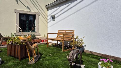 a yard with a bench and some plants and flowers at A Casiña do Camiño in Baamonde