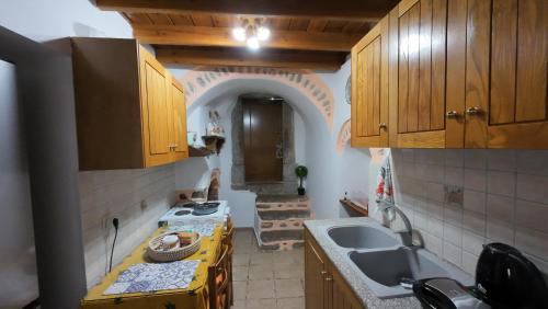 a kitchen with a stove and a sink and an archway at Elata Stone Retreat Traditional Village House in Chios