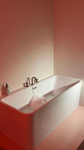 a white bath tub with a faucet in a bathroom at Kartuli Hotel in Batumi