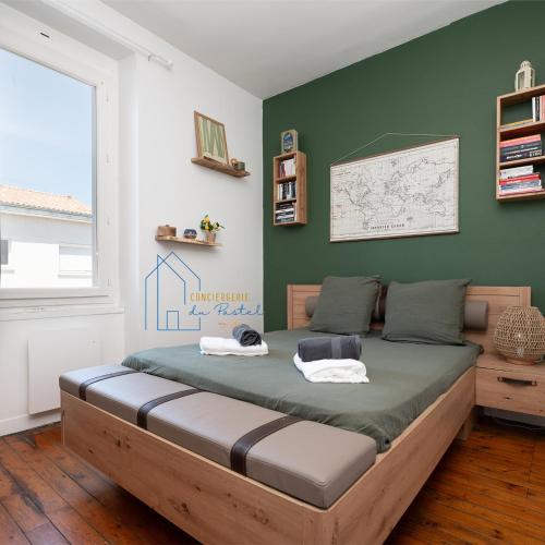 a bedroom with a bed with a green wall at Le Pastel Albigeois Parking & jardin 1km Unesco in Albi