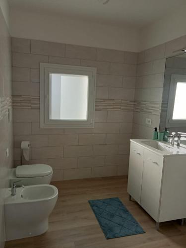 a bathroom with a toilet and a sink and a mirror at Agriturismo al rosari in Aquiléia