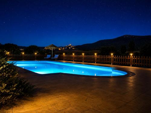 a swimming pool at night with a fence at Cortijo El Búho - Casa rural con piscina privada en Montefrío in Montefrío