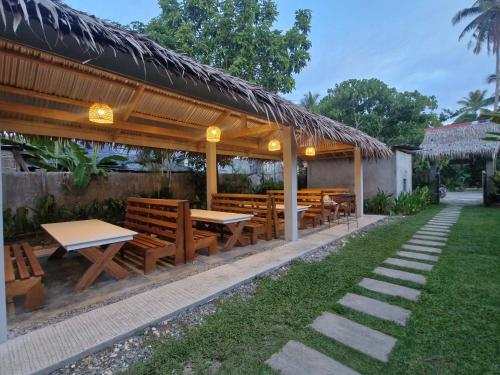 a pavilion with wooden benches and tables in a yard at Yayay Siargao - Generator & Starlink in General Luna