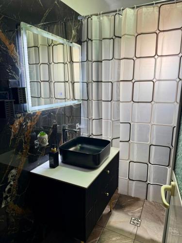 a bathroom with a black sink and a mirror at Flat in Leskovik in Leskovik
