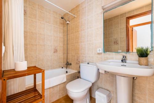 a bathroom with a toilet and a sink and a tub at Apartamentos Mar Blanca by Mauter Villas in Cala Blanca