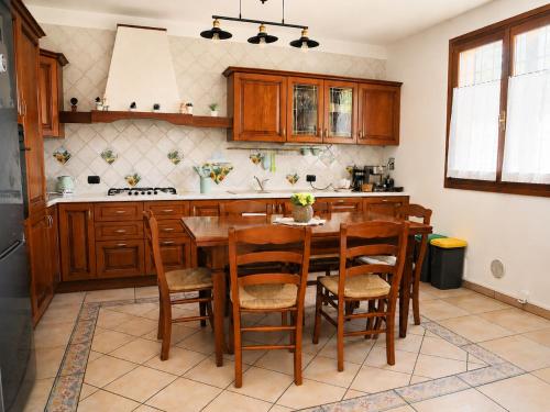 a kitchen with a wooden table and chairs at Villa Porpora Luxury Design in Modena