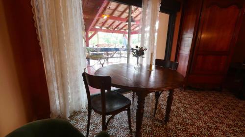 a wooden table and chairs in a room with a window at Le Gîte des Jardins d'Ispahan in Prignac-et-Marcamps
