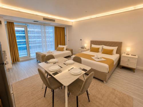a hotel room with two beds and a table and chairs at WHITE TITANIC LUXURY Sea View & Studios in Mamaia Sat/Năvodari