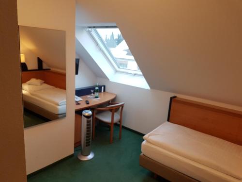 a small room with a bed and a desk and a bedroom at Hotel Zur Mühle in Lengerich