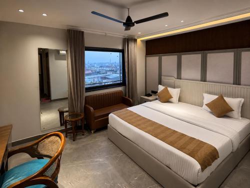 a bedroom with a bed and a couch and a window at Classic Hotel in Pānīpat