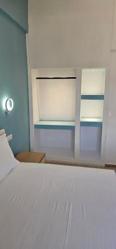a bedroom with a white bed and a window at Sidari Escapes By The Beach in Sidari