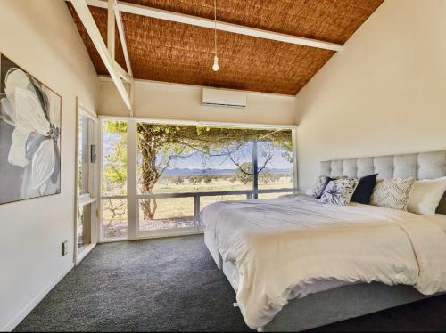 a bedroom with a large bed and a large window at Bunnugal House in Dunkeld