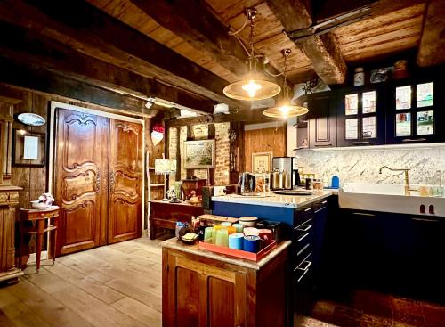 a large kitchen with wooden cabinets and a sink at Le Colombier de Cyrano et Roxane in Bergerac