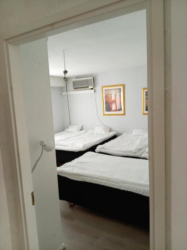 two beds in a room with a mirror at Kattohuoneisto antinkatu in Pori