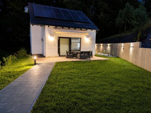 a house with solar panels on the side of a yard at Skośne Domki 2 in Chmielno