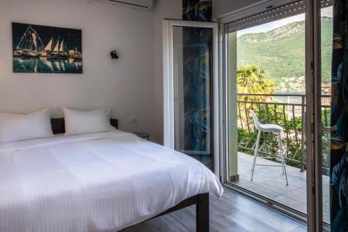 a bedroom with a bed and a balcony at Seaside Village in Kamenari