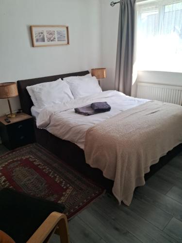 a bedroom with a large bed with white sheets and a window at 4 mereside walk in Manchester