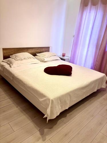a large white bed with a red hat on it at DaMa in Kaštela