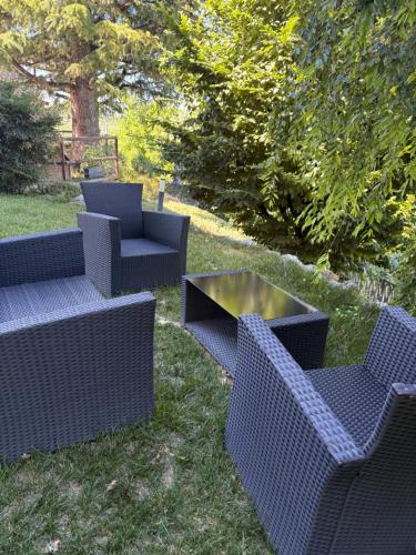 a group of chairs and a table in the grass at Cannubi San Lorenzo Appartamento in Barolo