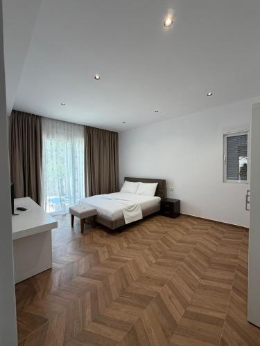 a bedroom with a bed and a wooden floor at Blue Days Villa 2 in Shkalle Stenojt