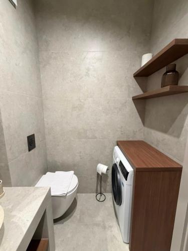 a bathroom with a toilet and a microwave at MJ Apartments in Łomża