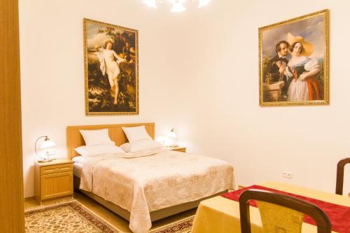 - une chambre avec un lit et deux photos sur le mur dans l'établissement Authentic Klauzal Apartment, à Budapest