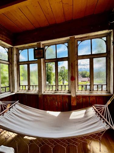 a hammock in a room with windows at Prociówka in Ciche