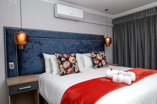 a bedroom with a large bed with a red blanket at Lasaro Guest Lodge in Bethlehem