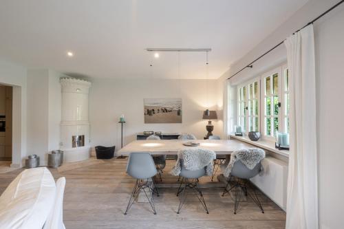 a white kitchen with a table and chairs at Sommerhaus in Keitum
