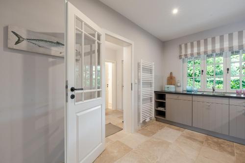 a kitchen with a white door and a counter at Sommerhaus in Keitum