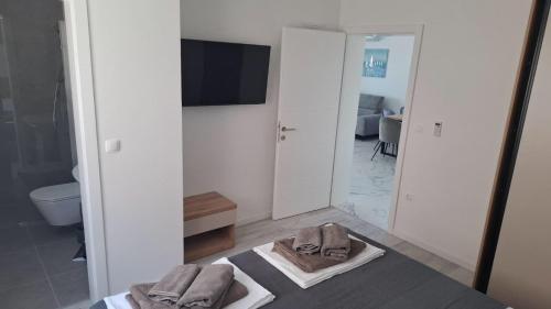 a bathroom with a mirror and a bed with towels at Mima apartments in Povljana