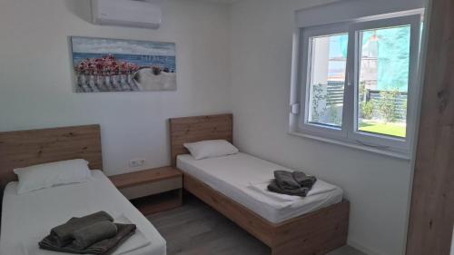 a room with two beds and a window at Mima apartments in Povljana