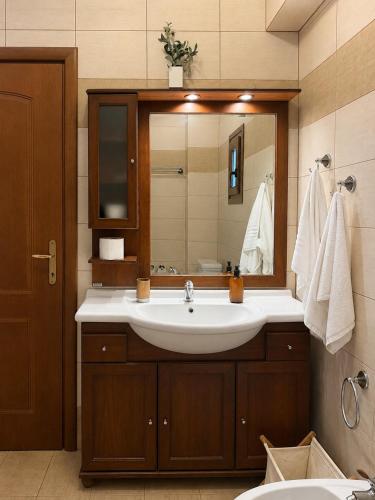a bathroom with a sink and a mirror at Daphne Villas in Kriopigi