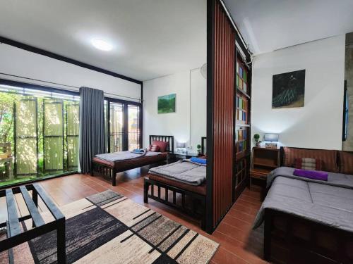 a living room with two beds and a couch at Villa Him Doi in Ban Mae Rim Nua
