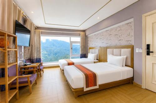 a hotel room with two beds and a window at Terravia Hotel Sapa Moutain View in Sapa
