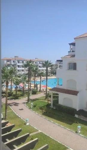 a building with palm trees next to a beach at Garden Beach 2 in Casablanca