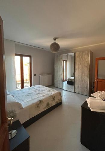 a bedroom with a large bed and a large window at Respiro di luna in Pescopagano