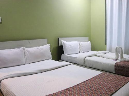a room with two beds and a rug at Brichyalaya Kohalpur in Kohalpur