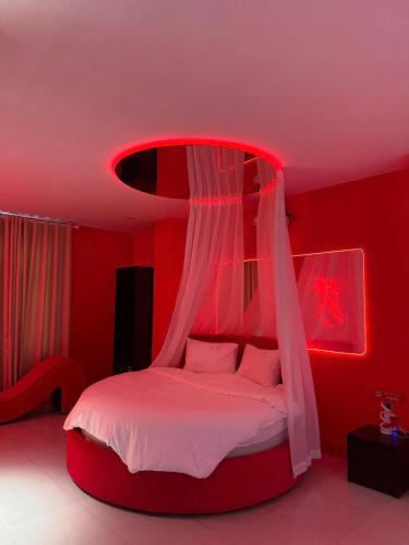 a red bedroom with a bed with a canopy at Đào Hoa Love Hotel Đà Nẵng in Danang
