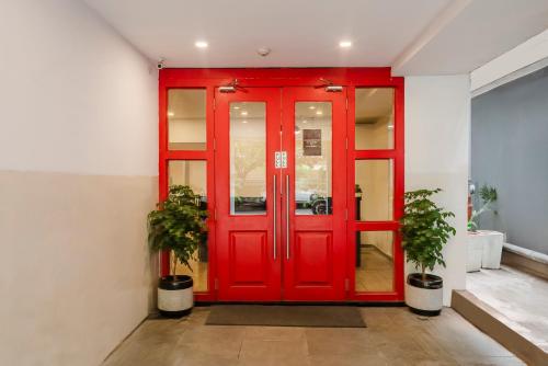 a red door in a room with two potted plants at RCC Hotels Elite Begumpet in Hyderabad