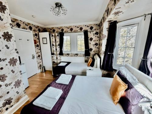 a bedroom with a large bed and floral wallpaper at The Bridge House in Hounslow
