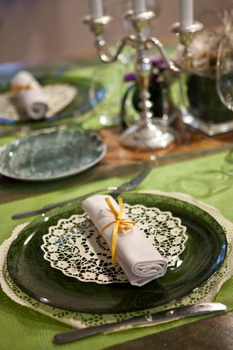 a green and white plate with a napkin on a table at Relais Casa Orter in Risano