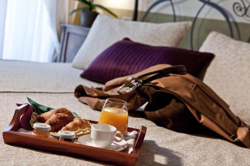 a tray of breakfast foods and a purse on a bed at Relais Casa Orter in Risano