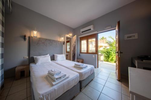 a bedroom with a large bed with towels on it at Ariadnes Holiday Accommodation in Apidias Lakos