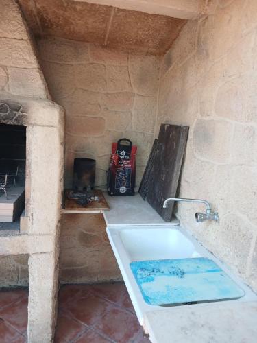 a bath tub in a stone room with a sink at Private pool and garden in Cunit